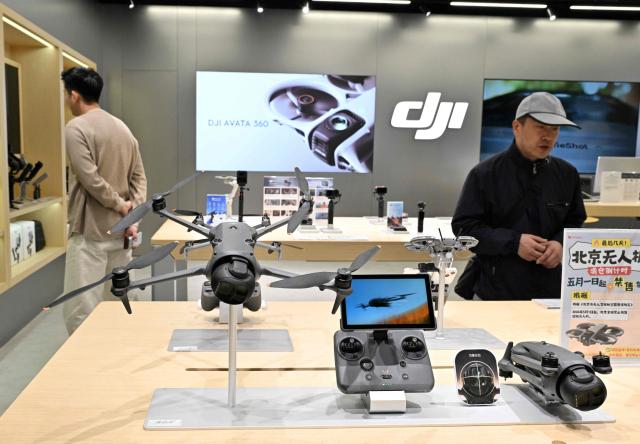 People visit a DJI store by company manufacturer DJI (Da-Jiang Innovators) at a mall in Beijing on April 28, 2026. On May 1, 2026 Beijing government will ban new consumer drone sales. (Photo by Adek BERRY / AFP)
