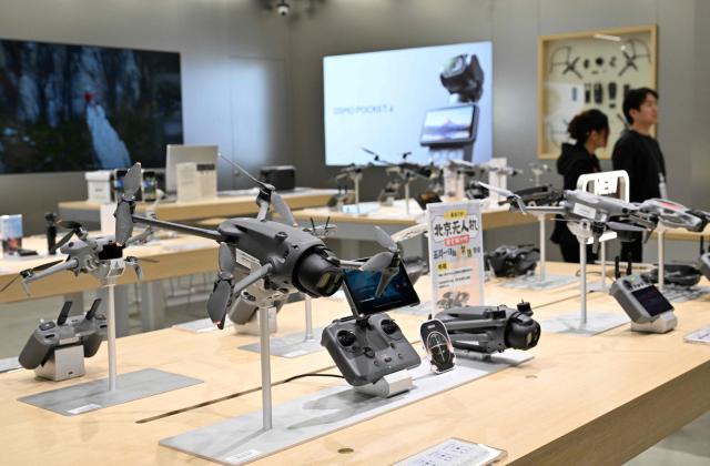 Drone models produced by company manufacturer DJI (Da-Jiang Innovators) are on displayed at a mall in Beijing on April 28, 2026. On May 1, 2026 Beijing government will ban new consumer drone sales. (Photo by Adek BERRY / AFP)