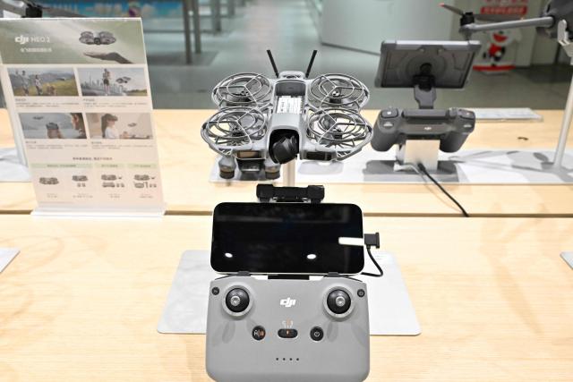 A DJI Neo2 model drone produced by company manufacturer DJI (Da-Jiang Innovators) is displayed at a mall in Beijing on April 28, 2026. On May 1, 2026 Beijing government will ban new consumer drone sales. (Photo by Adek BERRY / AFP)