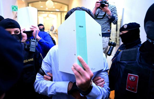 Two defendants in handcuffs are escorted to the courtroom by justice officers as a trial starts at court in Wiener Neustadt, Austria, on April 28, 2026, over a plot to attack a Taylor Swift concert in Vienna. The main suspect, who has been in detention since his arrest in August 2024, is facing terror offenses and other charges, prosecutors said. (Photo by ROLAND SCHLAGER / APA / AFP) / Austria OUT