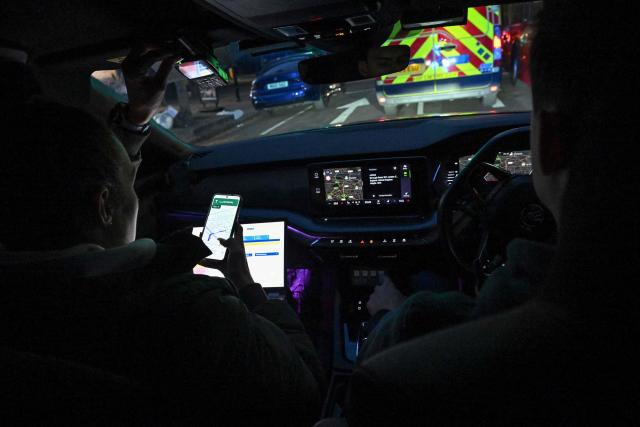 Police officer Hailey Carr (L) navigates as police officer Hayden O'Connor (R) drives a Metropolitan Police interceptor vehicle towards the scene of a mobile phone theft in central London April 25, 2026. London's police force has invested heavily in clamping down on the phenomenon which has led the metropolis to be dubbed Europe's phone theft capital. (Photo by Ben STANSALL / AFP) / TO GO WITH Britain-police-theft-crime,REPORTAGE by Kimberley MANNION