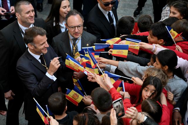 France's President and Co-Prince of Andorra Emmanuel Macron (L) and Andorra's Prime Minister Xavier Espot Zamora (C) meets with students at a school in Santa Coloma, on the second day of his visit to the microstate of Andorra on April 28, 2026. (Photo by Ed JONES / POOL / AFP)