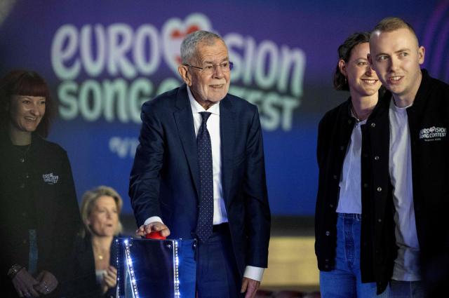 Austrian President Alexander Van Der Bellen (C) pushes the red button to start a light show for the official opening of the stage prior to the 70th Eurovision Song Contest (ESC) at the Wiener Stadthalle in Vienna, Austria on April 28, 2026. Vienna will host the two semi-finals of the ESC taking place on May 12 and May 14 and the final on May 16, 2026. (Photo by Joe Klamar / AFP)