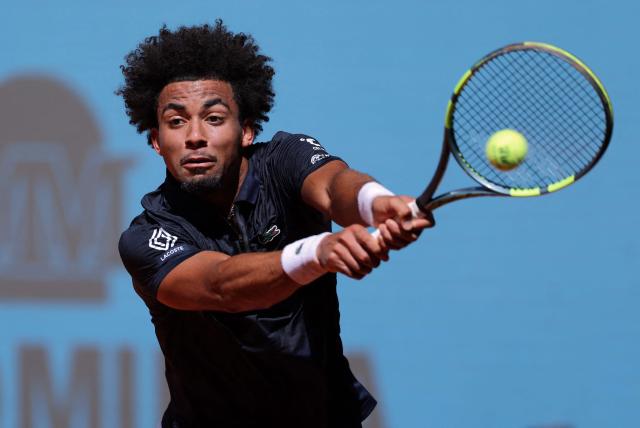 France’s Arthur Fils returns the ball to Argentina’s Tomas Martin Etcheverry during their 2026 ATP Tour Madrid Open tennis tournament singles match at the Caja Magica in Madrid, on April 28, 2026. (Photo by Thomas COEX / AFP)