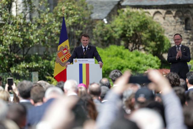 France's President and Co-Prince of Andorra Emmanuel Macron (L) reacts as he delivers a speech flanked by Andorra's Prime Minister Xavier Espot Zamora at the Placa del Poble square in Andorra la Vella, on the second day of his visit to the microstate of Andorra on April 28, 2026. (Photo by Valentine CHAPUIS / POOL / AFP)