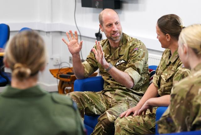 Britain's Prince William, Prince of Wales (C) speaks with members of the female RAF team, which reflects his ongoing interest in the experience and welfare of women in the Armed Forces, during his visit to RAF Valley in Anglesey in north-west Wales on April 28, 2026, as part of celebrations marking its 85th anniversary. (Photo by Dominic Lipinski / POOL / AFP)