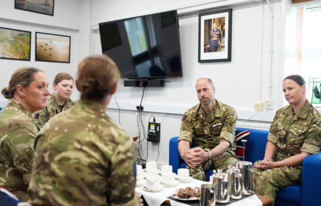 Britain's Prince William, Prince of Wales (2R) speaks with members of the female RAF team, which reflects his ongoing interest in the experience and welfare of women in the Armed Forces, during his visit to RAF Valley in Anglesey in north-west Wales on April 28, 2026, as part of celebrations marking its 85th anniversary. (Photo by Dominic Lipinski / POOL / AFP)