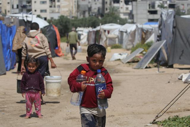 Children fetch drinking water at the Bureij camp for Palestinian refugees in the central Gaza Strip on April 28, 2026. The majority of Gaza's 2.4 million people have been displaced, often multiple times, by the war that began with Hamas's attack on southern Israel on October 7, 2023. With displaced families living in tented camps, with serious concerns raised about their living conditions. (Photo by Eyad Baba / AFP)