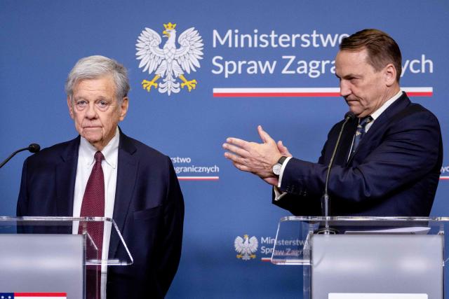 Polish Foreign Minister Radoslaw Sikorski (R) applauds for the US President's Special Envoy for Belarus John Cole as they address a press conference at the ministry building in Warsaw on April 28, 2026, after an exchange of prisoners. Poland on April 28 released a jailed Russian archaeologist, who was wanted by Ukraine, as part of a multi-country swap deal that also saw a Polish journalist freed from a Belarusian jail. (Photo by Wojtek RADWANSKI / AFP)