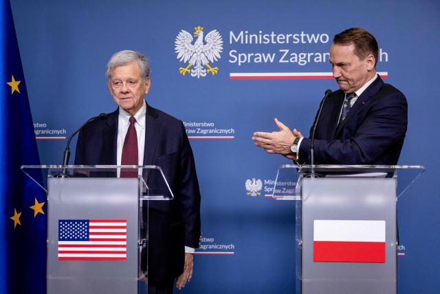 Polish Foreign Minister Radoslaw Sikorski (R) applauds for the US President's Special Envoy for Belarus John Cole as they address a press conference at the ministry building in Warsaw on April 28, 2026, after an exchange of prisoners. Poland on April 28 released a jailed Russian archaeologist, who was wanted by Ukraine, as part of a multi-country swap deal that also saw a Polish journalist freed from a Belarusian jail. (Photo by Wojtek RADWANSKI / AFP)