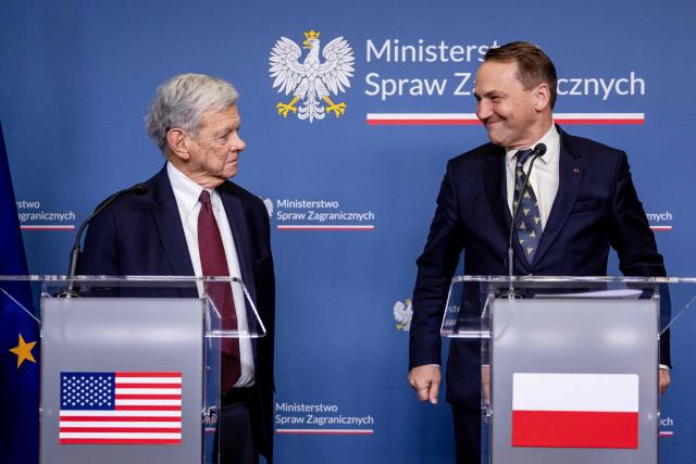 Polish Foreign Minister Radoslaw Sikorski (R) smiles at the US President's Special Envoy for Belarus John Cole as they address a press conference at the ministry building in Warsaw on April 28, 2026, after an exchange of prisoners. Poland on April 28 released a jailed Russian archaeologist, who was wanted by Ukraine, as part of a multi-country swap deal that also saw a Polish journalist freed from a Belarusian jail. (Photo by Wojtek RADWANSKI / AFP)