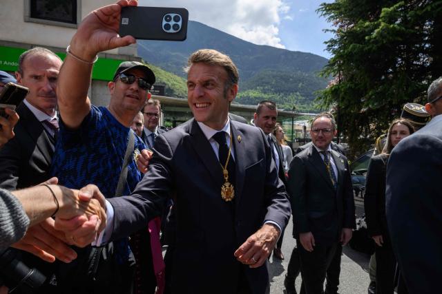 France's President and Co-Prince of Andorra Emmanuel Macron shakes hands with residents, next to Andorra's Prime Minister Xavier Espot Zamora (R), after delivering a speech at the Placa del Poble square in Andorra la Vella, on the second day of his visit to the microstate of Andorra on April 28, 2026. (Photo by Ed JONES / POOL / AFP)