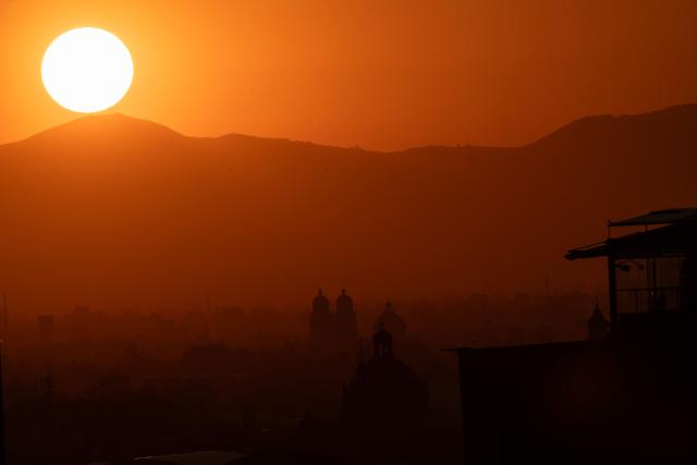 The sun rises behind mountains at dawn in Mexico City on April 28, 2026, as the meteorological service reports a heatwave expected to affect at least 27 states, with temperatures reaching up to 45 degrees Celsius in the northern state of Sonora. (Photo by Yuri CORTEZ / AFP)