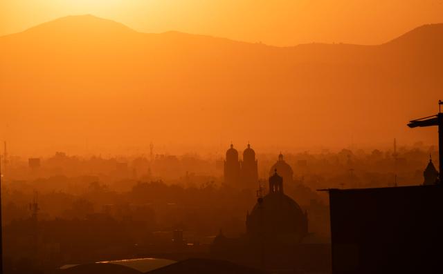 The sun rises behind mountains at dawn in Mexico City on April 28, 2026, as the meteorological service reports a heatwave expected to affect at least 27 states, with temperatures reaching up to 45 degrees Celsius in the northern state of Sonora. (Photo by Yuri CORTEZ / AFP)