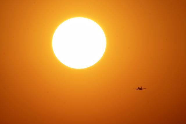 A commercial aircraft approaches for landing at Benito Juarez International Airport at dawn in Mexico City on April 28, 2026, as the meteorological service reports a heatwave expected to affect at least 27 states, with temperatures reaching up to 45 degrees Celsius in the northern state of Sonora. (Photo by Yuri CORTEZ / AFP)