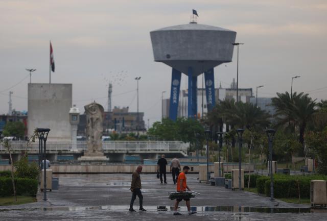 People walk through Al-Umma Park during rainfall in Baghdad on April 28, 2026. Iraq has been experiencing heavy rainfall since the beginning of this year, leading to flooding. The country had been facing severe drought due to low rainfall and water cuts from upstream countries like Iran and Turkey. Dams and rivers are now overflowing as water returns after a prolonged dry spell. (Photo by AHMAD AL-RUBAYE / AFP)