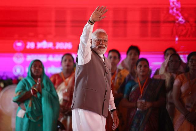 India's Prime Minister Narendra Modi waves to supporters upon his arrival to address a public meeting for women in Varanasi on April 28, 2026. (Photo by Niharika KULKARNI / AFP)