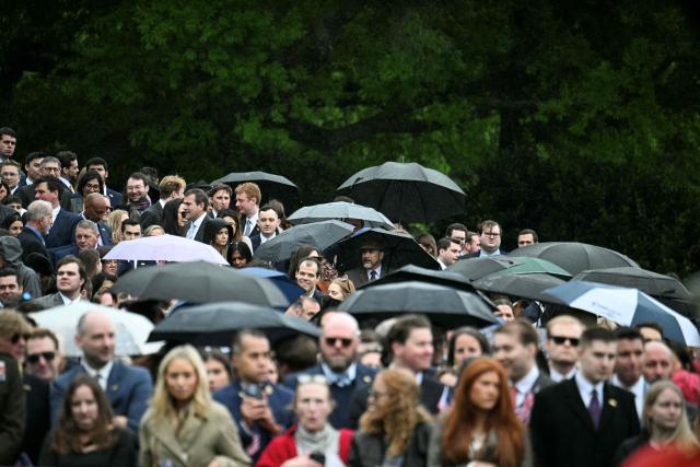 Guests wait in the rain for US President Donald Trump and First Lady Melania Trump to greet Britain's King Charles III and Queen Camilla for an arrival ceremony on the South Lawn of the White House in Washington, DC, on April 28, 2026. (Photo by Jim WATSON / AFP)
