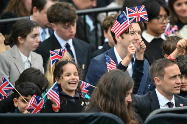 Guests wave flags as they wait for US President Donald Trump and First Lady Melania Trump to greet Britain's King Charles III and Queen Camilla during an arrival ceremony on the South Lawn of the White House in Washington, DC, on April 28, 2026. (Photo by Mandel NGAN / AFP)