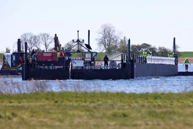 Members of a rescue team are seen on a special barge intended to bring a stranded humpback whale to the North Sea, in the Wismarer Bucht (Wismar Bay) of the Baltic Sea off the island of Poel, northern Germany, close to the village of Faehrdorf-Hof, on April 28, 2026. German rescuers on April 28 hauled the stranded humpback whale into a special boat due to carry it to deeper waters, in the latest attempt to free the cetacean whose ordeal has captured hearts in Germany for weeks. The whale, dubbed "Timmy" by German media, and its struggle for survival have gripped the country since it beached on a sandbank near the city of Luebeck, far from its natural habitat in late March. (Photo by Danny Gohlke / AFP)