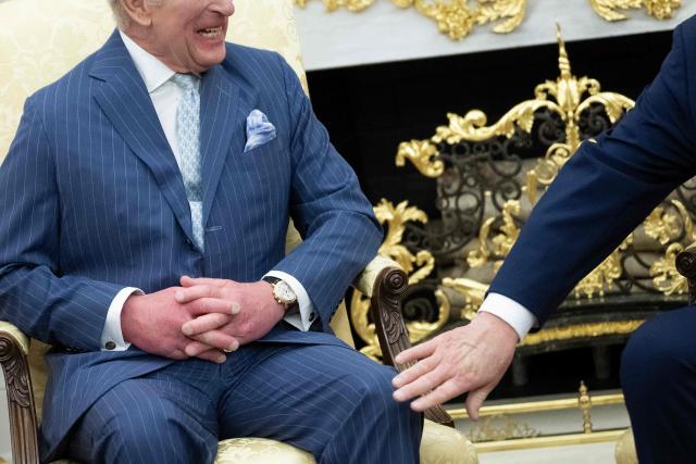 US President Donald Trump pats Britain's King Charles III on the leg during a meeting in the Oval Office of the White House April 28, 2026, in Washington, DC. (Photo by Brendan Smialowski / AFP)