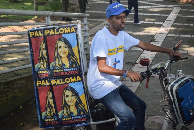 A supporter carries images depicting Colombia's right-wing presidential candidate Paloma Valencia during a campaign rally in Popayan, Cauca department, Colombia on April 28, 2026. Colombia will hold a presidential election on May 31, 2026. (Photo by Francisco Calderon / AFP)