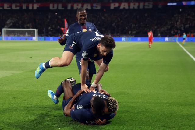 Paris Saint-Germain's French forward #10 Ousmane Dembele (down) celebrates with Paris Saint-Germain's French midfielder #14 Desire Doue, Paris Saint-Germain's Georgian forward #07 Khvicha Kvaratskhelia and Paris Saint-Germain's Portuguese defender #25 Nuno Mendes after scoring his team fifth goal during the UEFA Champions League semi-final first leg football match between Paris Saint-Germain (PSG) and Bayern Munich at the Parc des Princes in Paris on April 28, 2026. (Photo by Alain JOCARD / AFP)