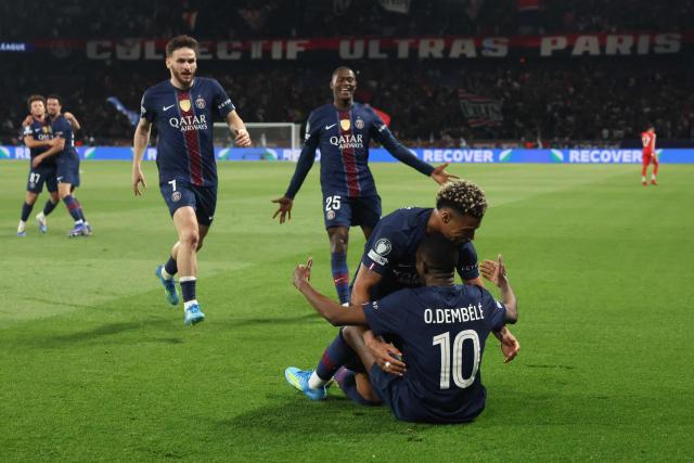 Paris Saint-Germain's French forward #10 Ousmane Dembele (down) celebrates with Paris Saint-Germain's French midfielder #14 Desire Doue (C), Paris Saint-Germain's Georgian forward #07 Khvicha Kvaratskhelia (L) and Paris Saint-Germain's Portuguese defender #25 Nuno Mendes (2L) after scoring his team fifth goal during the UEFA Champions League semi-final first leg football match between Paris Saint-Germain (PSG) and Bayern Munich at the Parc des Princes in Paris on April 28, 2026. (Photo by Alain JOCARD / AFP)