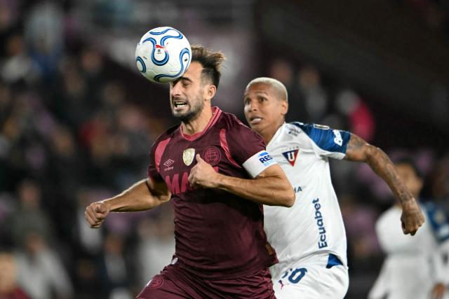 Lanus' defender #24 Carlos Izquierdoz heads the ball next to Liga de Quito's Brazilian forward #16 Deyverson during the Copa Libertadores group stage football match between Argentina's Lanus and Ecuador's Liga de Quito at the Ciudad de Lanus stadium in Lanus, Buenos Aires province, Argentina on April 28, 2026. (Photo by Luis ROBAYO / AFP)