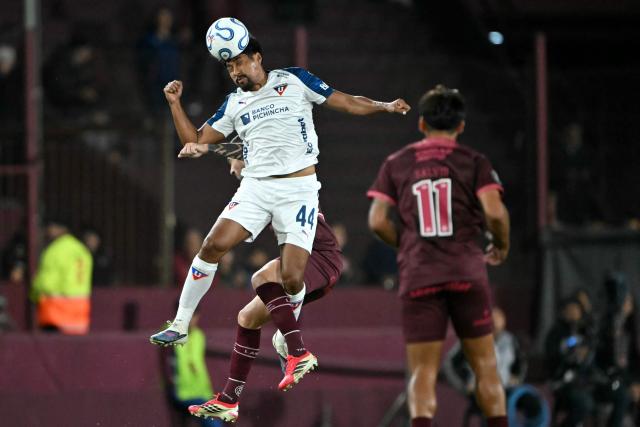 Liga de Quito's defender #44 Luis Segovia heads the ball over Lanus' midfielder #23 Ramiro Carrera during the Copa Libertadores group stage football match between Argentina's Lanus and Ecuador's Liga de Quito at the Ciudad de Lanus stadium in Lanus, Buenos Aires province, Argentina on April 28, 2026. (Photo by Luis ROBAYO / AFP)