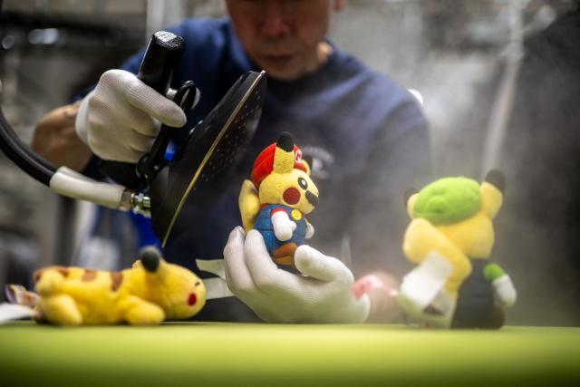 In this picture taken on April 27, 2026, dry-cleaning professional Masakazu Shimura steam-cleans a soft toy at the facility of Cleaning Yonmarusan in Fuefuki city of Yamanashi Prefecture. A worn-out Pikachu plushie, tired teddy bear or stained stuffed animal can all get a new lease on life at a Japanese laundry service making beloved toys squeaky clean again. (Photo by Philip FONG / AFP) / TO GO WITH AFP STORY: Japan-culture-toys-internet, by Hiroshi Hiyama