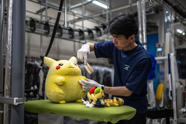 In this picture taken on April 27, 2026, dry-cleaning professional Masakazu Shimura brushes a soft toy at the facility of Cleaning Yonmarusan in Fuefuki city of Yamanashi Prefecture. A worn-out Pikachu plushie, tired teddy bear or stained stuffed animal can all get a new lease on life at a Japanese laundry service making beloved toys squeaky clean again. (Photo by Philip FONG / AFP) / TO GO WITH AFP STORY: Japan-culture-toys-internet, by Hiroshi Hiyama