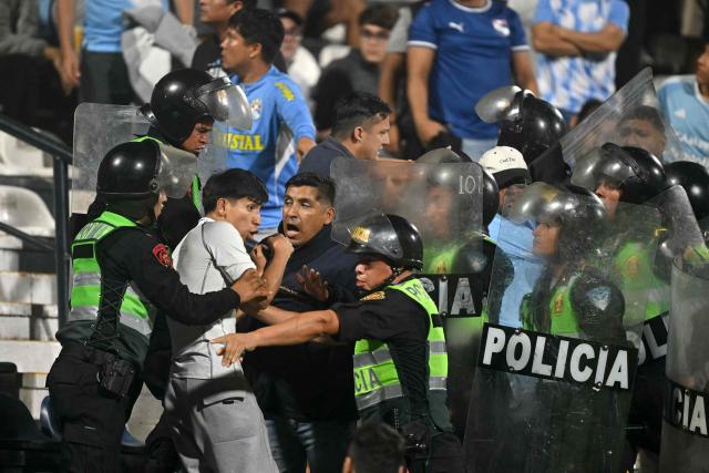 A Sporting Cristal fan clashes with police officers during the Copa Libertadores group stage football match between Peru's Sporting Cristal and Colombia's Junior at the Alejandro Villanueva stadium in Lima on April 28, 2026. (Photo by ERNESTO BENAVIDES / AFP)