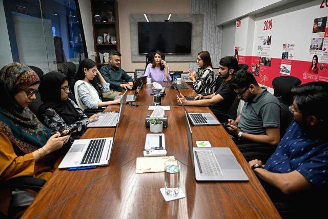 This photograph taken on April 7, 2026 shows Sara Saeed Khurram, a doctor and chief executive officer of digital health firm Sehat Kahani, conducting a meeting with her employees inside their office in Karachi. Gallup surveys and doctors' associations suggest more than a third of Pakistani female medical graduates never enter the profession -- or leave it after marriage -- due to lack of family support, poor childcare facilities, and harassment. But an initiative by digital health firm Sehat Kahani helped women back into the workforce by providing a digital platform to connect home-based, mostly female doctors, with patients in underserved communities. (Photo by Rizwan TABASSUM / AFP)