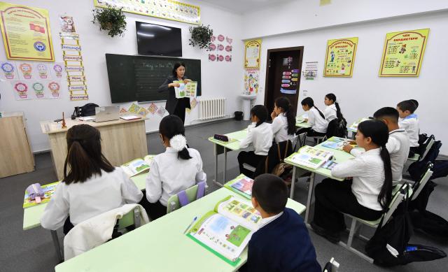 English teacher Kanykei Sovetova, 30, teaches pupils at a school in the northwestern village of Bukara, some 100 km from the Kyrgyz capital of Bishkek, on February 6, 2026. (Photo by Vyacheslav OSELEDKO / AFP)