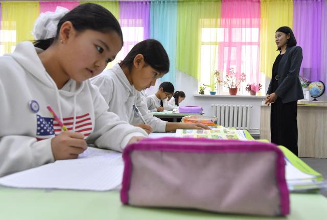 English teacher Kanykei Sovetova, 30, teaches pupils at a school in the northwestern village of Bukara, some 100 km from the Kyrgyz capital of Bishkek, on February 6, 2026. (Photo by Vyacheslav OSELEDKO / AFP)
