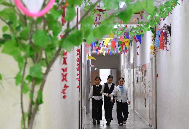 Pupils walk in a school's hallway in the northwestern village of Bukara, some 100 km from the Kyrgyz capital of Bishkek, on February 6, 2026. (Photo by Vyacheslav OSELEDKO / AFP)