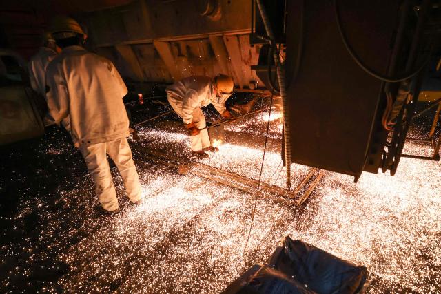 Workers are seen in a steel casting workshop in Lianyungang, in China’s eastern Jiangsu province on April 28, 2026. (Photo by CN-STR / AFP) / China OUT