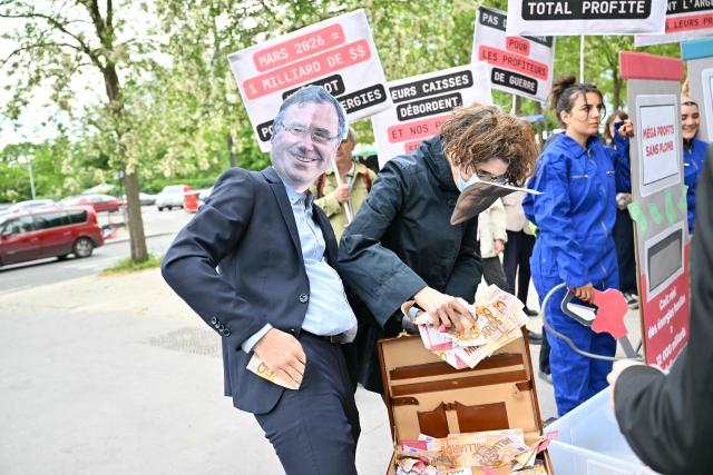 A protester wears a mask bearing Patrick Pouyamne, Chairman and CEO of TotalEnergies, during a staged protest action called by 350.org, Action Justice Climat, Attac France, Greenpeace France and Extinction Rebellion France against French company TotalEnergies marking the publication of its first-quarter results in Paris on April 29, 2026. French oil and gas giant TotalEnergies reported on April 29, 2026, a first-quarter net profit of $5.8 billion, up by nearly 50% year-on-year, driven by rising oil prices linked to the war in the Middle East. (Photo by Martin LELIEVRE / AFP)