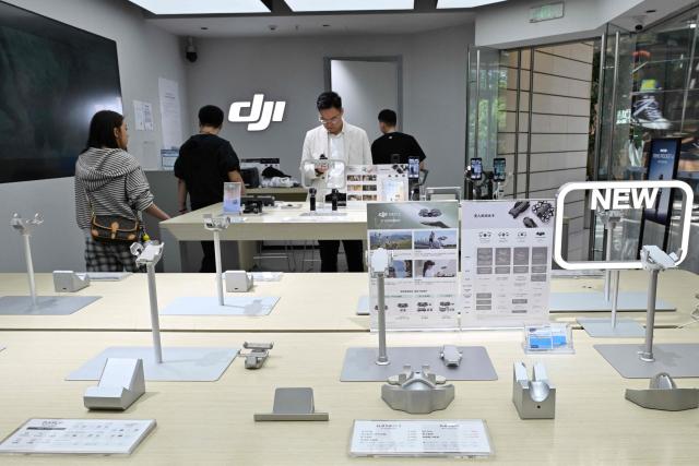 Empty display stands for drones are seen at a DJI store at a mall in Beijing on April 29, 2026, ahead a ban against the sale of consumer drones by the city government which begins on May 1. (Photo by Adek BERRY / AFP)