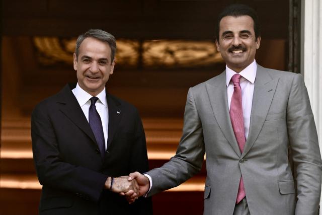 Greece's Prime Minister Kyriakos Mitsotakis (L) welcomes the Emir of Qatar Tamim bin Hamad Al Thani before their meeting in Athens on April 29, 2026. (Photo by Aris MESSINIS / AFP)