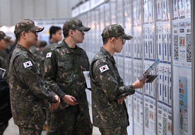 South Korean soldiers look at job opportunities during the annual job fair for soldiers scheduled for discharge, hosted by the South Korean Defence Ministry, at KINTEX exhibition hall in Goyang on April 29, 2026. (Photo by Jung Yeon-je / AFP)