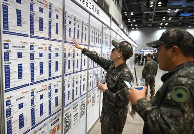 South Korean soldiers look at job opportunities during the annual job fair for soldiers scheduled for discharge, hosted by the South Korean Defence Ministry, at KINTEX exhibition hall in Goyang on April 29, 2026. (Photo by Jung Yeon-je / AFP)