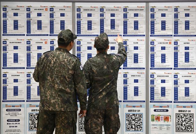 South Korean soldiers look at job opportunities during the annual job fair for soldiers scheduled for discharge, hosted by the South Korean Defence Ministry, at KINTEX exhibition hall in Goyang on April 29, 2026. (Photo by Jung Yeon-je / AFP)