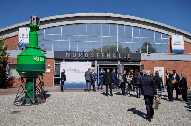 Delegates stand in front of the venue of German National Maritime Conference in Emden, northern Germany, on April 29, 2026. The National Maritime Conference (NMK) is the Federal Government’s central event for supporting the maritime industry, attended by around 800 representatives from business, politics and science, and has established itself as a driver of new ideas and a platform for exchange. It has been held every two years since 2000. (Photo by FOCKE STRANGMANN / AFP)