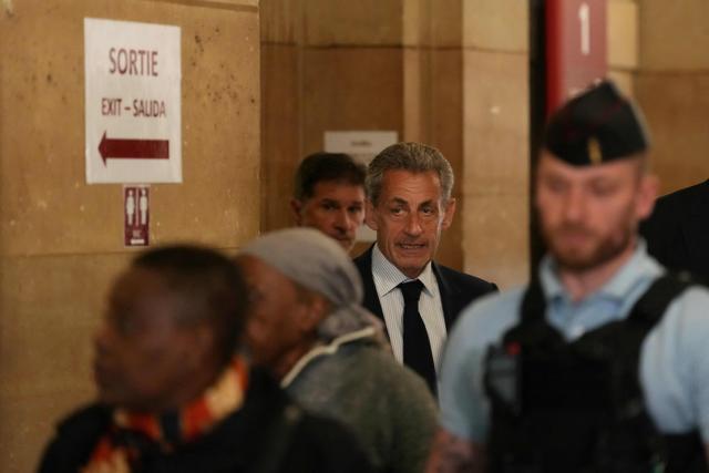 France's former President Nicolas Sarkozy (C) reacts as arrives to the courtroom after a break during his final hearing in his appeal trial over charges he had sought Libyan financing for his 2007 election in exchange for helping improve Tripoli's image after deadly bombing, at the Palais de Justice courthouse in Paris on April 29, 2026. (Photo by Dimitar DILKOFF / AFP)