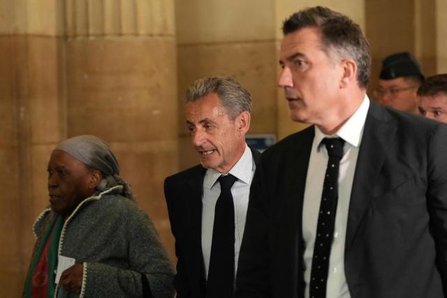 France's former President Nicolas Sarkozy (C) arrives to the courtroom after a break during his final hearing in his appeal trial over charges he had sought Libyan financing for his 2007 election in exchange for helping improve Tripoli's image after deadly bombing, at the Palais de Justice courthouse in Paris on April 29, 2026. (Photo by Dimitar DILKOFF / AFP)