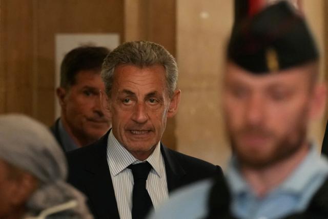 France's former President Nicolas Sarkozy (C) arrives to the courtroom after a break during his final hearing in his appeal trial over charges he had sought Libyan financing for his 2007 election in exchange for helping improve Tripoli's image after deadly bombing, at the Palais de Justice courthouse in Paris on April 29, 2026. (Photo by Dimitar DILKOFF / AFP)