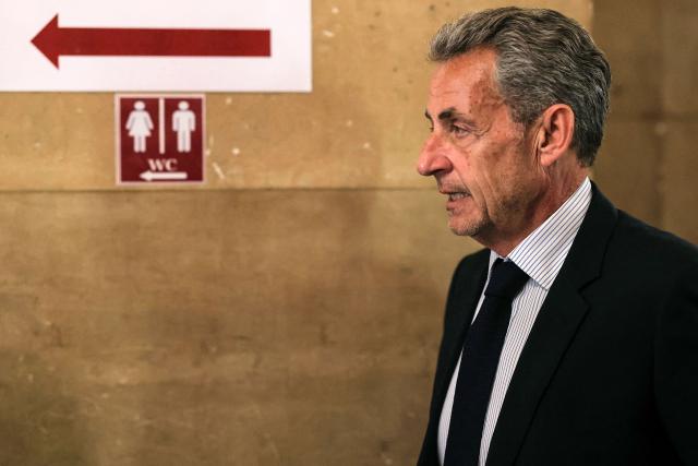 France's former President Nicolas Sarkozy arrives to the courtroom after a break during his final hearing in his appeal trial over charges he had sought Libyan financing for his 2007 election in exchange for helping improve Tripoli's image after deadly bombing, at the Palais de Justice courthouse in Paris on April 29, 2026. (Photo by Thomas SAMSON / AFP)