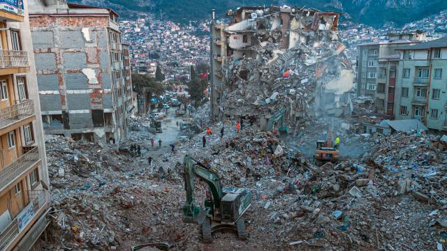 (FILES) This aerial photograph taken on February 20, 2023 shows diggers removing the rubble of collapsed buildings in Antakya, southern Turkey. Nothing is "as it was before" the earthquake that devastated the ancient city and southern Turkey in February 2023, killing at least 53,000 people : Three years after the disaster, residents are denouncing opaque reconstruction plans that threaten to empty the old town and jeopardise its multicultural identity. Once bustling, adjacent to working-class neighbourhoods as well as Muslim, Christian and Jewish places of worship, Kurtulus Avenue is now a vast construction site where listed historic buildings are being hastily rebuilt, with support from the European Union. The old town of Antakya was home to more than 13,000 residents before the earthquake, but virtually no homes will remain, according to the controversial new urban development plan. (Photo by Sameer Al-DOUMY / AFP)